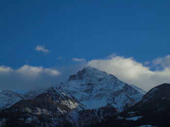 Scenic view of snowcapped mountains against blue sky