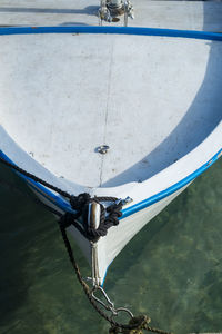 High angle view of boat tied up with ropes moored on sea