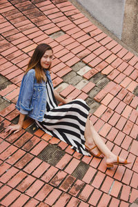 Full length portrait of woman sitting outdoors