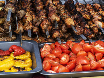 High angle view of meat in skewers with vegetables in container at market stall