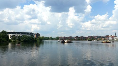 River in city against cloudy sky