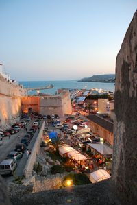 High angle view of cityscape by sea against clear sky