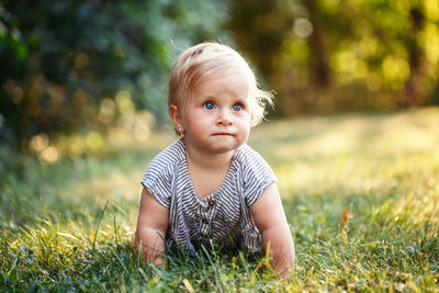 Portrait of cute baby girl on field