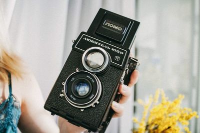 Close-up of woman hand holding vintage camera