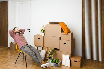 Mature man unpacking things from boxes while moving in new apartment.