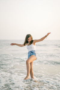 Full length of young woman jumping in sea