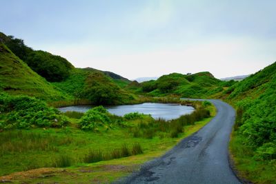 Road by lake against sky