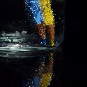 Close-up of glass on table against black background