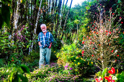 Full length portrait of man standing against plants