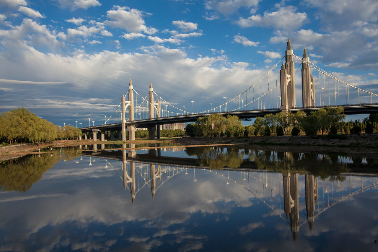 cloud - sky, reflection, water, sky, connection, built structure, bridge, bridge - man made structure, architecture, waterfront, nature, no people, transportation, travel destinations, suspension bridge, river, building exterior, outdoors