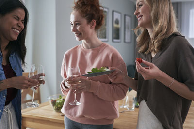 Cheerful females enjoying food at home