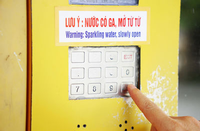 Cropped finger pressing on vending machine number pad to order drinks