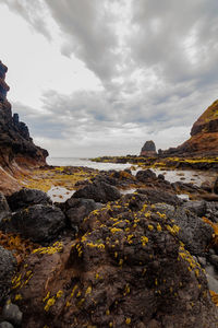 Rock formations on shore against sky