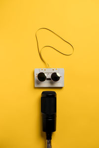 Close-up of audio equipment against yellow background