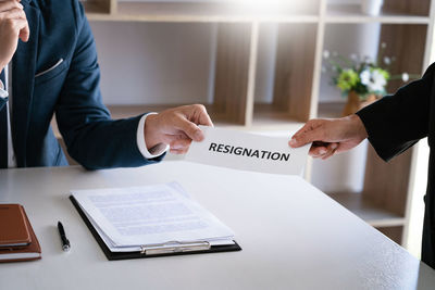 Midsection of man holding text on table