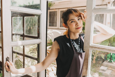 Portrait of woman standing by door