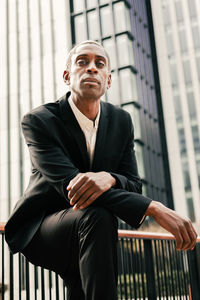 Confident black businessman leaning on railing