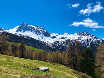 Scenic view of snowcapped mountains against blue sky