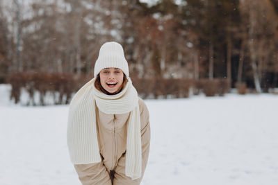 Portrait of young woman skiing on snow covered field during winter