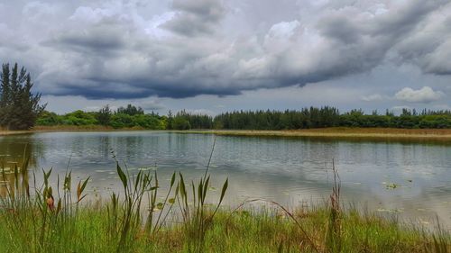 Scenic view of lake against cloudy sky