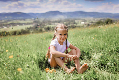 Full length of girl sitting on field