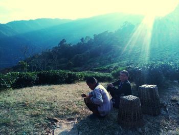 Rear view of men sitting on mountain