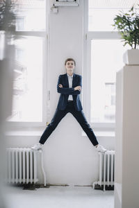 Portrait of confident businesswoman standing on heater in office