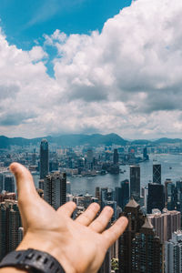 Midsection of man holding cityscape against sky