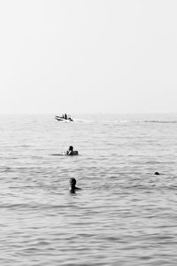 Man swimming in sea against clear sky