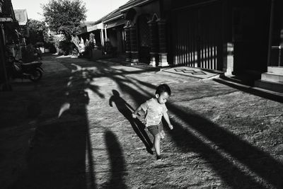 Girl walking on footpath in city