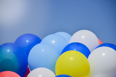 Low angle view of balloons against blue sky