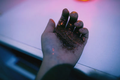 Cropped image of hand covered with glitter