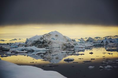 Scenic view of frozen lake against sky during sunset