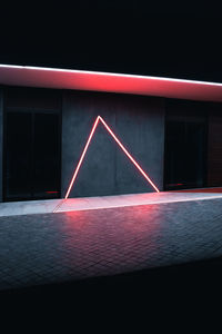Illuminated red building in city at night