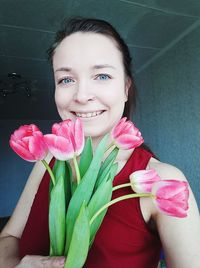 Portrait of smiling woman with pink flower