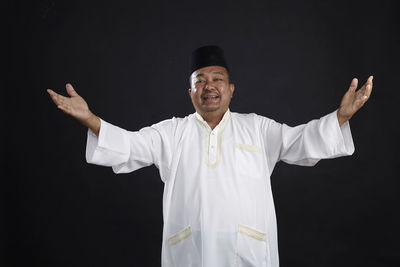 Man standing against black background