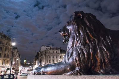 Statue of illuminated building in city