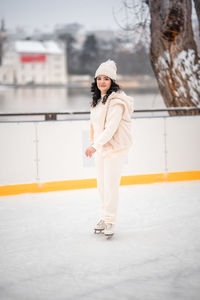 Full length of young woman standing against wall