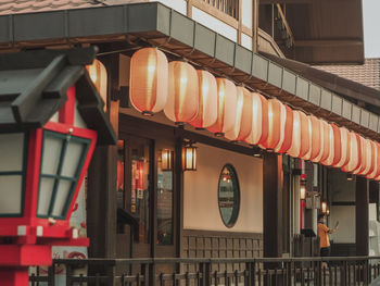 Illuminated lanterns hanging by building in city