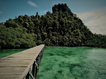 Scenic view of swimming pool by lake against sky