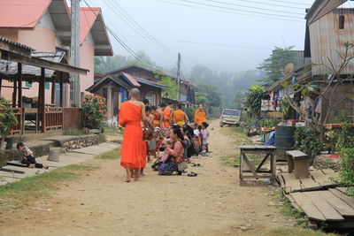 People walking on street amidst buildings in city