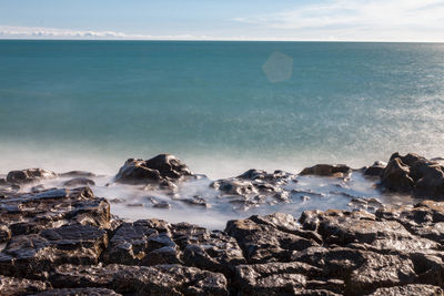 Rocks on beach against sky