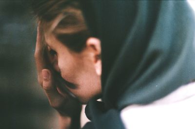 Close-up of woman covering face with hand outdoors