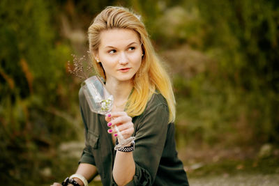 Portrait of a young woman drinking glass