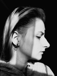 Close-up of young woman looking away in darkroom