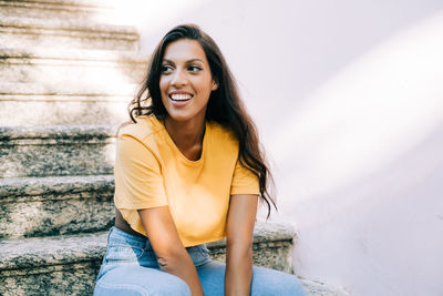 Portrait of smiling young woman sitting outdoors