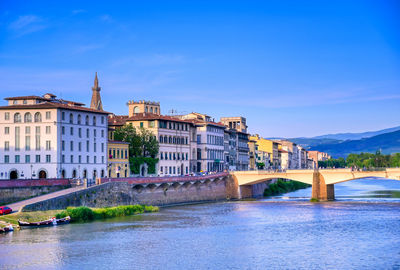 Bridge over river against buildings in city