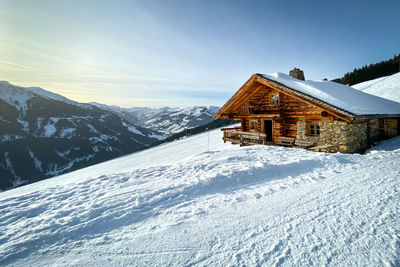 Snow covered landscape and houses against sky