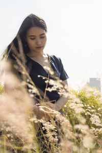 Portrait of a young woman standing on field