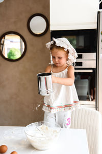 Little girl cooking pizza in the kitchen